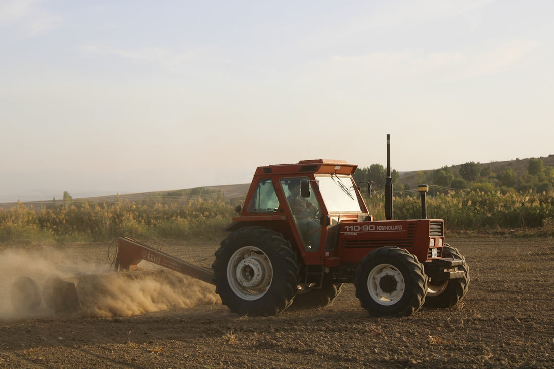 red and black tractor on brown field during daytime