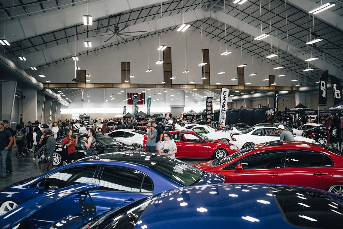 a group of people looking at cars in a showroom