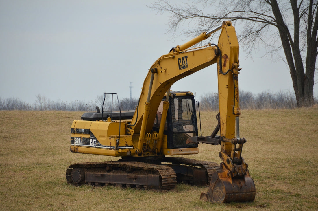 a large yellow excavator sitting in a field