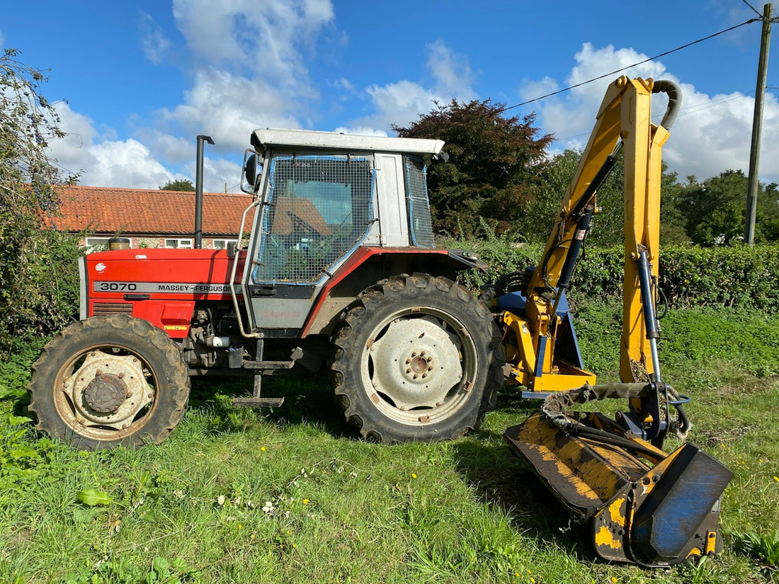 A tractor is parked in a field with a bulldozer