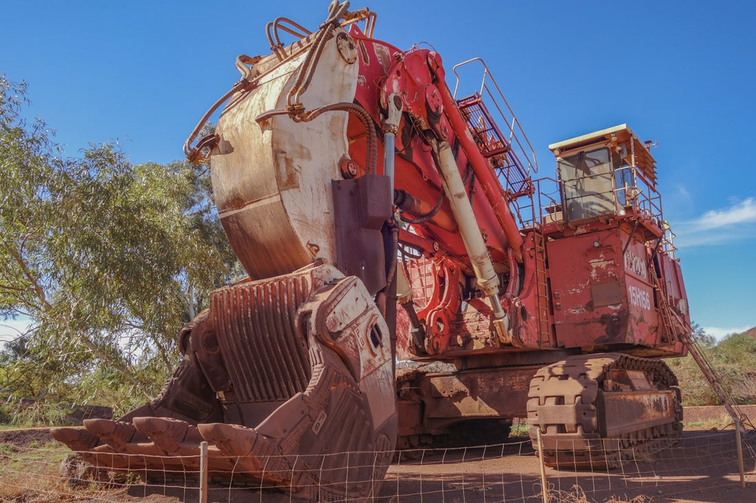 Rusty red and white mining excavator on red dirt